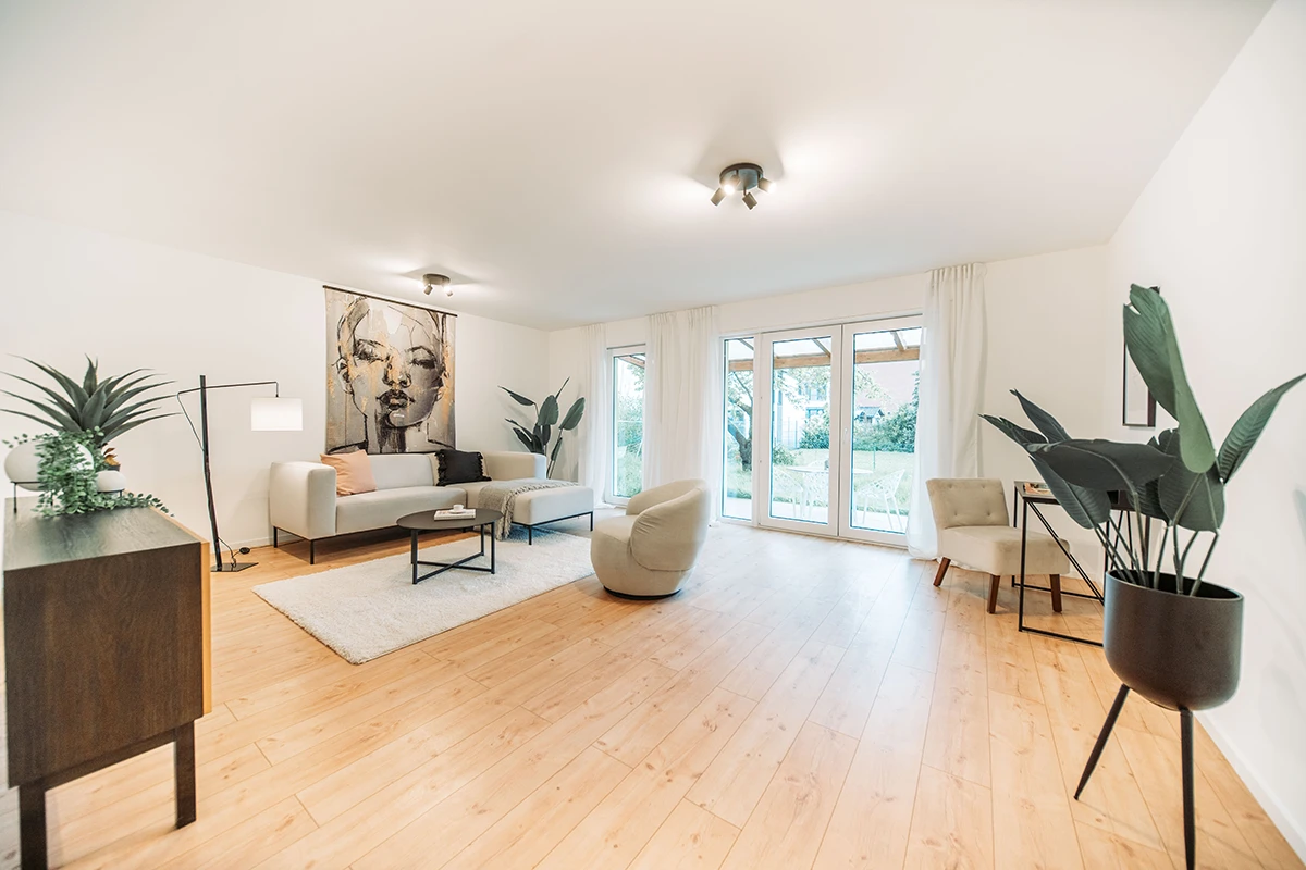 Offener Blick in ein hellen Wohnbereich mit Blick hinaus in den Garten